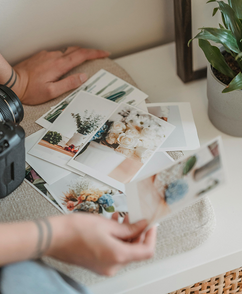 Person looking through a collection of printed photos, examining memories and images.